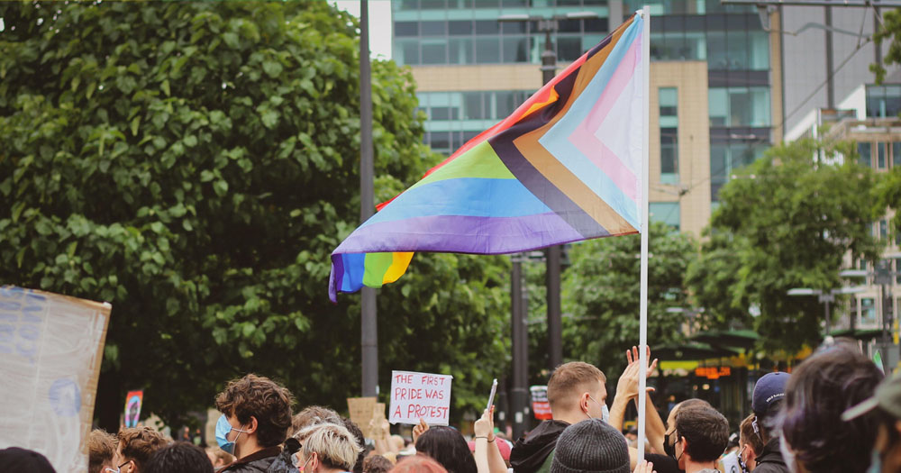 To mark Trans Day of Visibility 2022, the NXF have released a statement. The photograph shows the heads of protesters at a demonstration with the Progressive Pride flag waving.