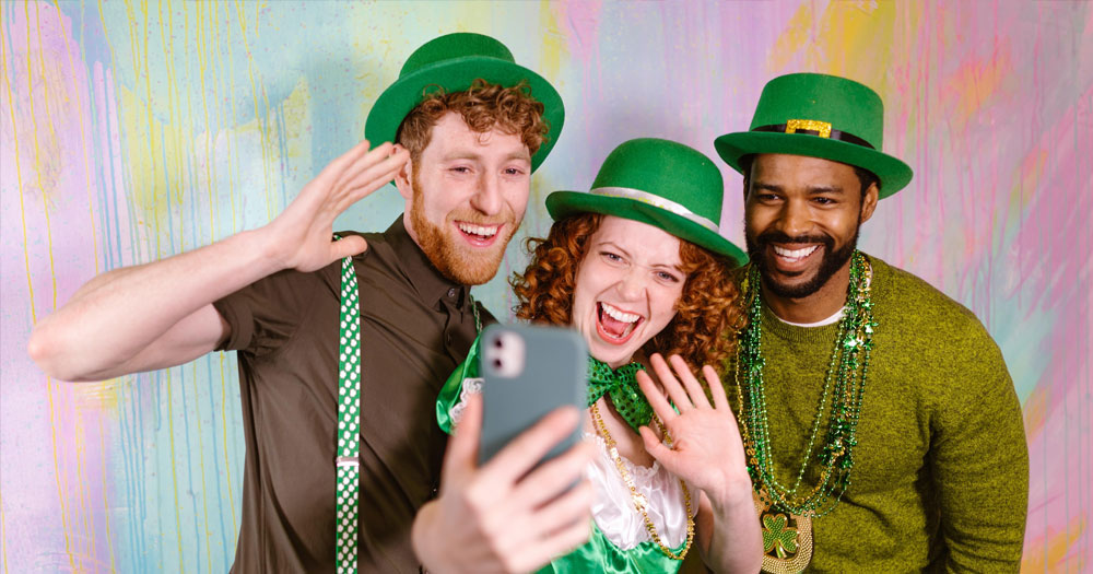 Three people dressed in St Patrick's Day attire posing for a selfie