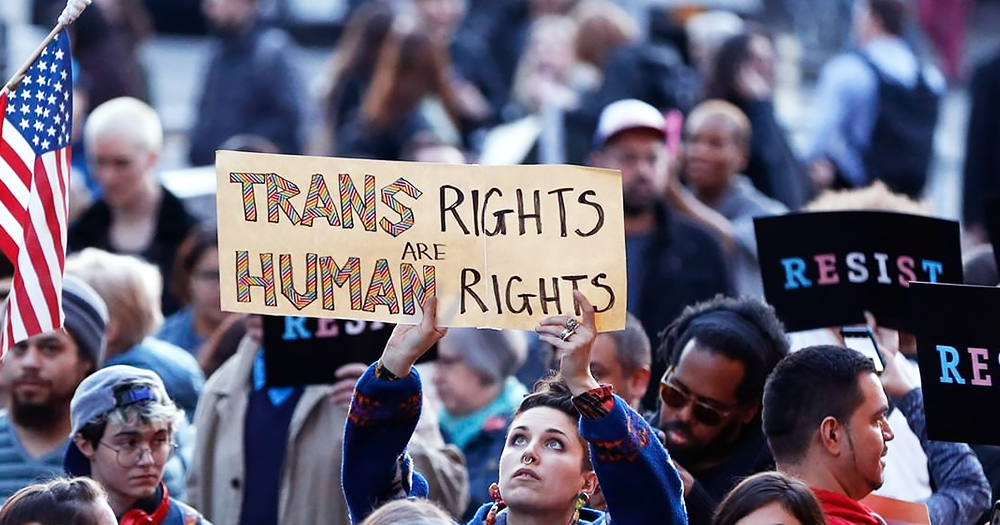 Alabama is to pass legislation prohibiting Trans Youth from attaining gender-affirming healthcare. the photograph show a person in a crowd holding a sign saying 