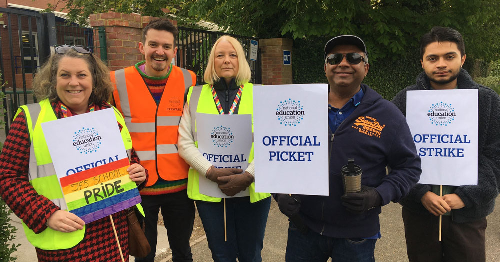 Photograph of 5 of the school staff on strike outside the John Fisher School in Croydon. They are all holding placards reading "Official Picket"..