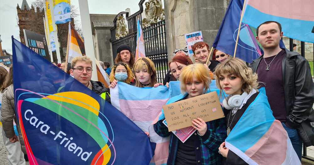 Cara-Friend, a Belfast-based LGBTQ+ non-profit, joins the protest while donning Transgender pride flags