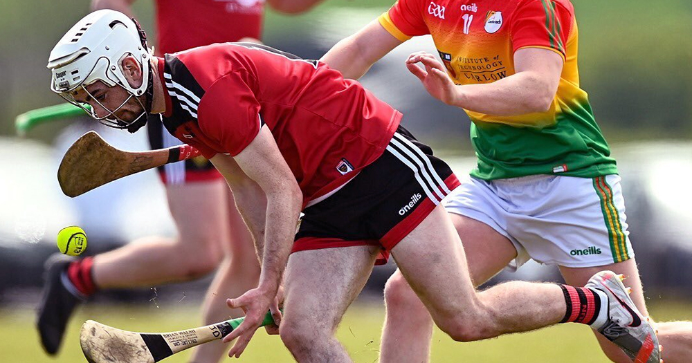 Two men playing camogie. This article is about out LGBTQ+ GAA players and attitudes towards them.