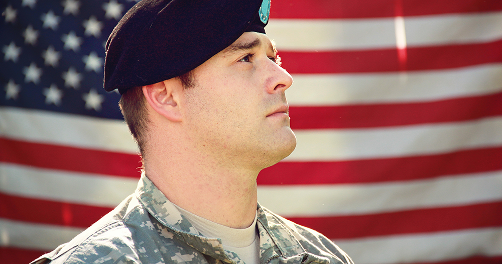 A US military service member poses in front of American flag, as HIV-Positive people can no longer be discriminated against.