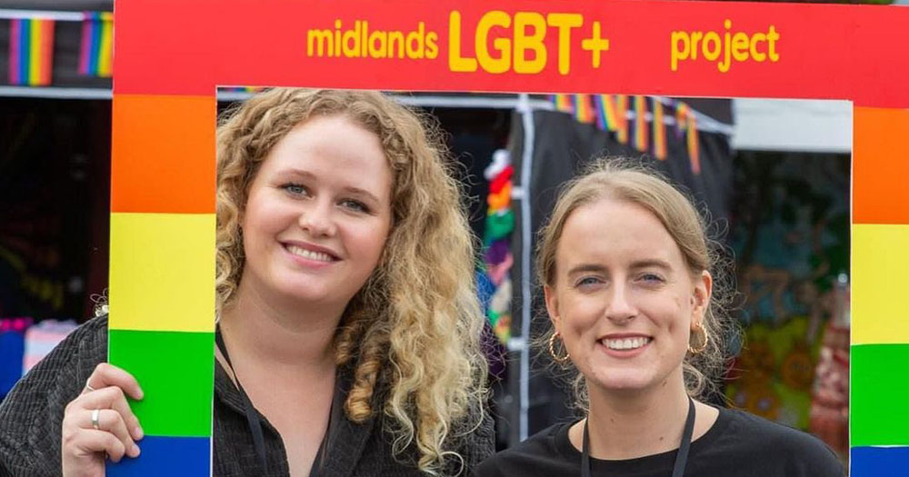 Midlands LGBT+ Project to launch in Offaly. The photograph shows two women looking through a rainbow coloured frame with Midlands LGBT+ Project written across the top.