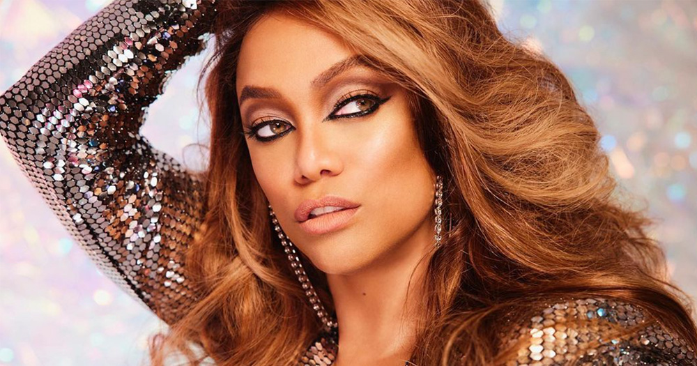 an image of Tyra Banks in a sequinned outfit with her left arm above her head.