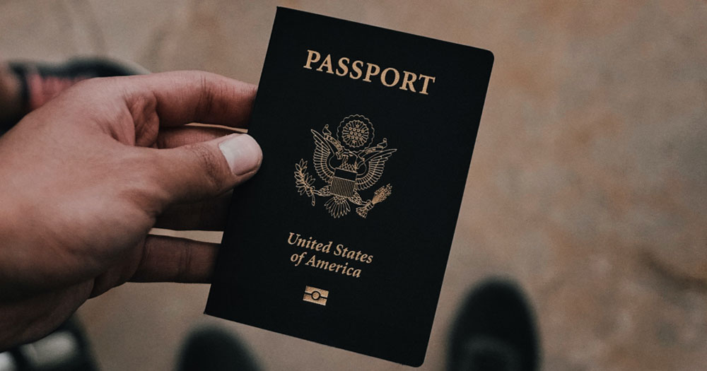 US have announced that they will introduce an X gender marker on passports from April 11. The photograph shows a close up of a US Passport with a POC's hand holding it.