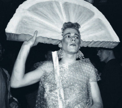 Black and white photo of someone dressed as a drink with a slice of lemon at Flikkers