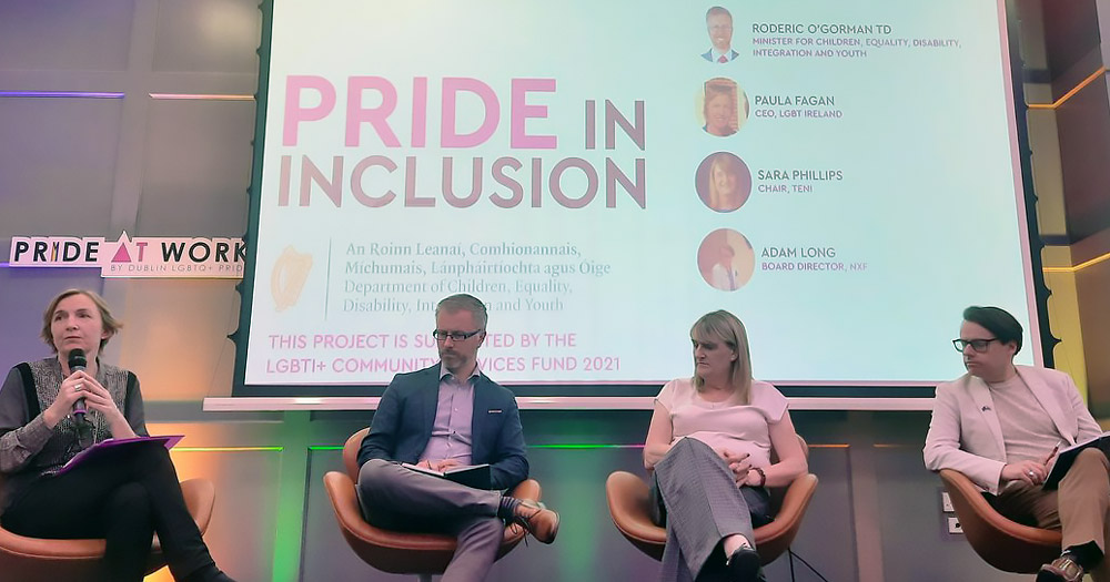 Four panellists on a stage, behind them a screen with 'Pride Inclusion' on it. From left to right, Paula Fagan, Roderic O’Gorman, Sara R Phillips and Adam Long discussing hate crime legislation in Ireland.
