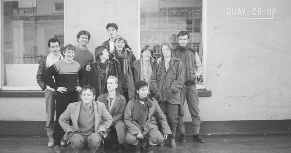 A photo from the 1980s showing a group of smiling young people standing outside a building