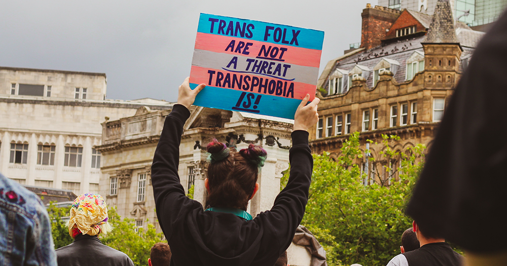 A person holds up a banner at a Trans+ Pride event such as in Cork.