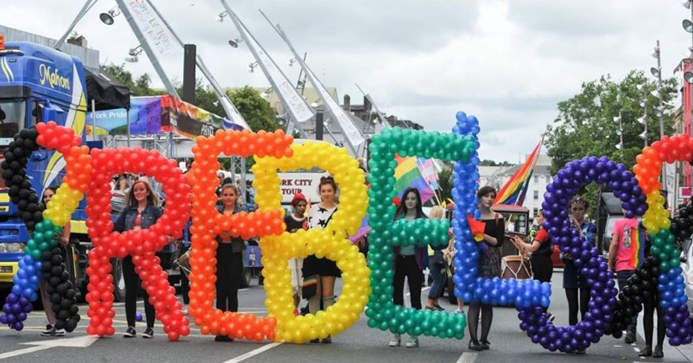 A photograph of giant letters made from balloons at Cork LGBT+ Pride. The letters read REBELS and are made in the Pride colours.