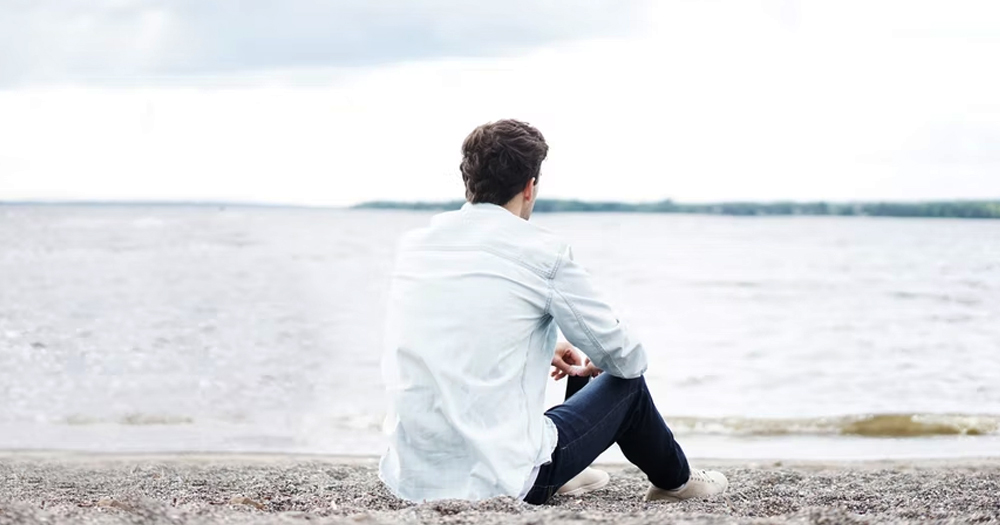 A man staring out at the sea. This article is about mental health.