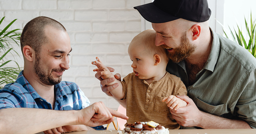 Two gay dads with their child. An Oireachtas committee released a report today containing recommendations on the recognition of international surrogacy agreements.