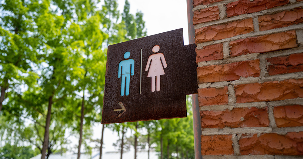 A sign for restrooms indicating one for men and one for women. Noah Ruiz, a trans man, was attacked for using the women’s restroom as he was told to do.