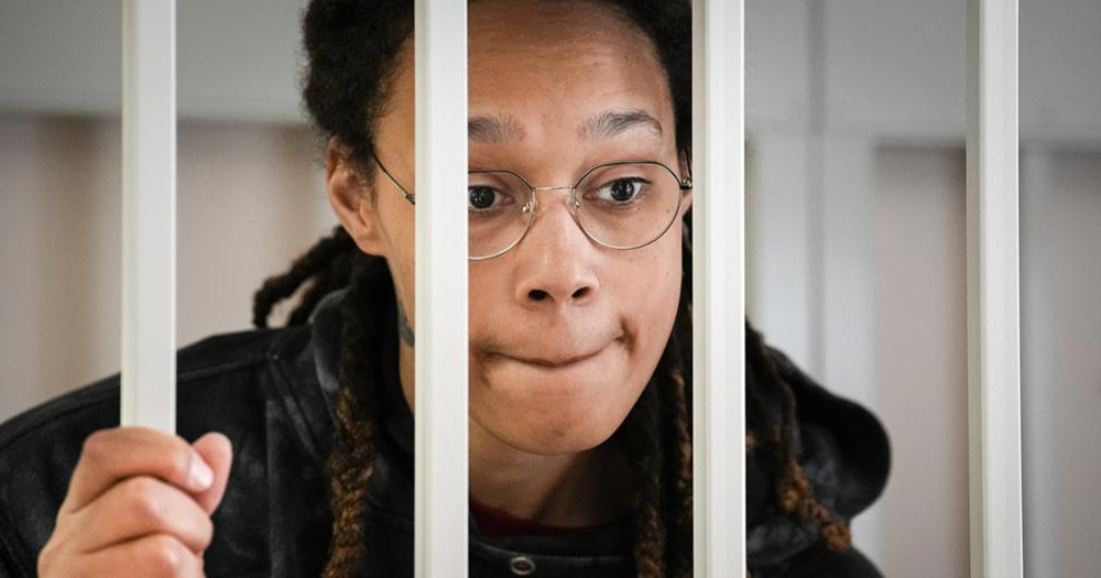 an image of Brittney Griner holding onto prison bars as she is detained in Russia.