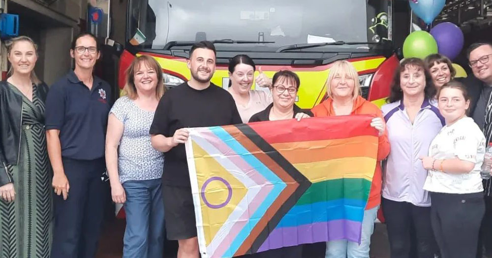 Members of Clonmel Pride and Clonmel Fire Service standing in front of a Pride falg to prommote the town's first ever Pride parade which takes place this Saturday.