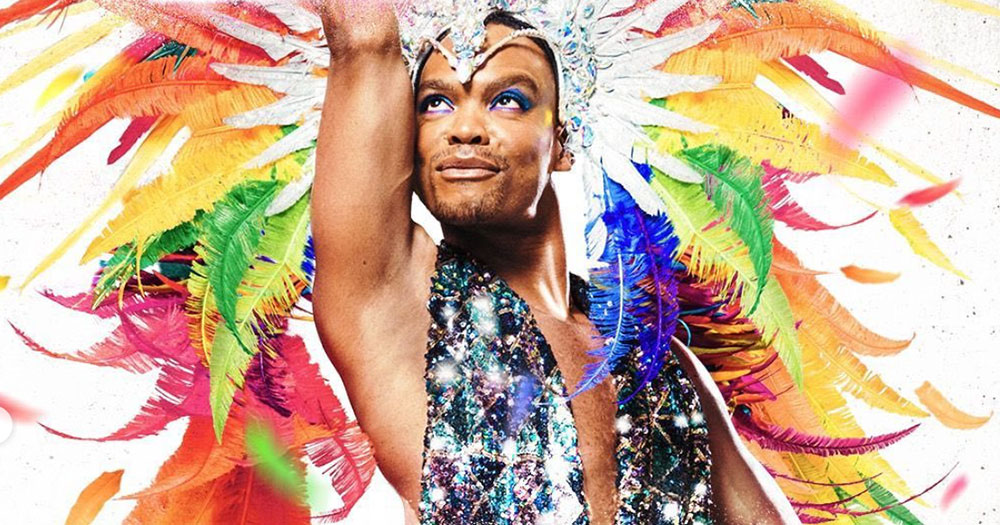 Freedom Unleashed poster: Johannes Radebe in a rainbow feather garment reaching to the sky
