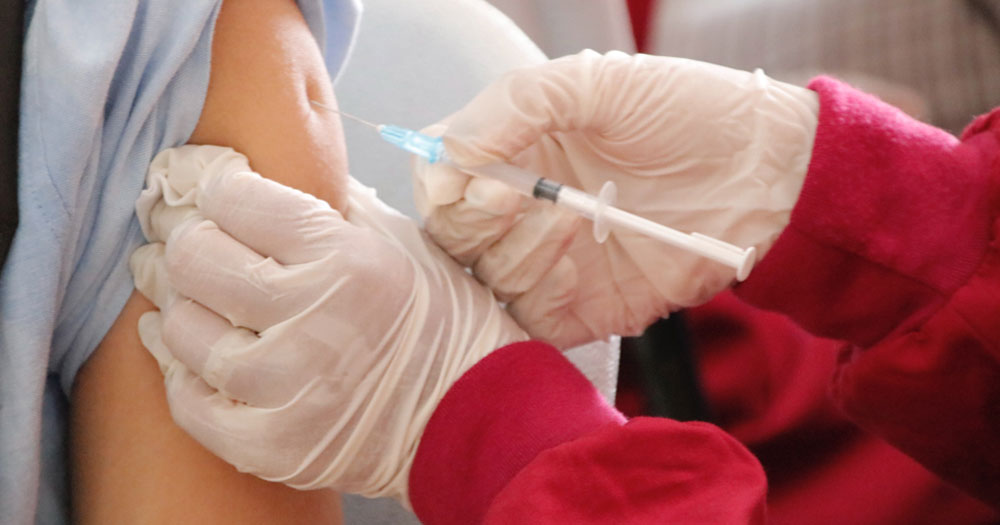 Close up of someone administering a vaccination to a patient