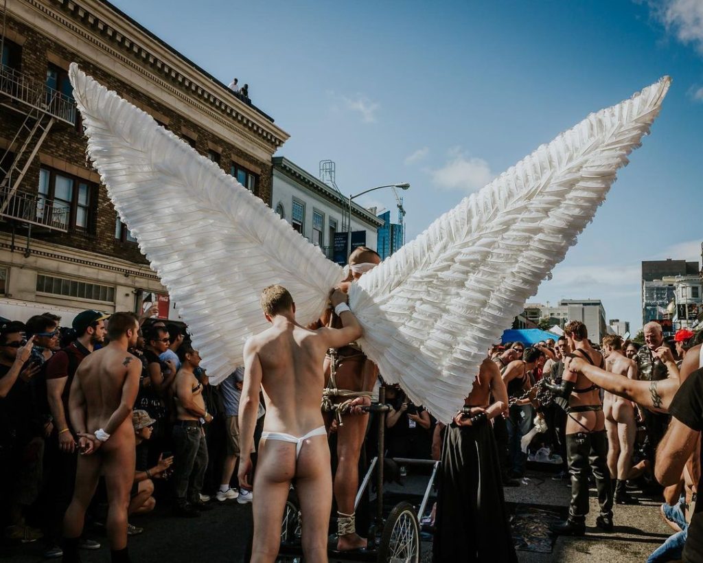 A person with giant angel wings at Folsom 2022.