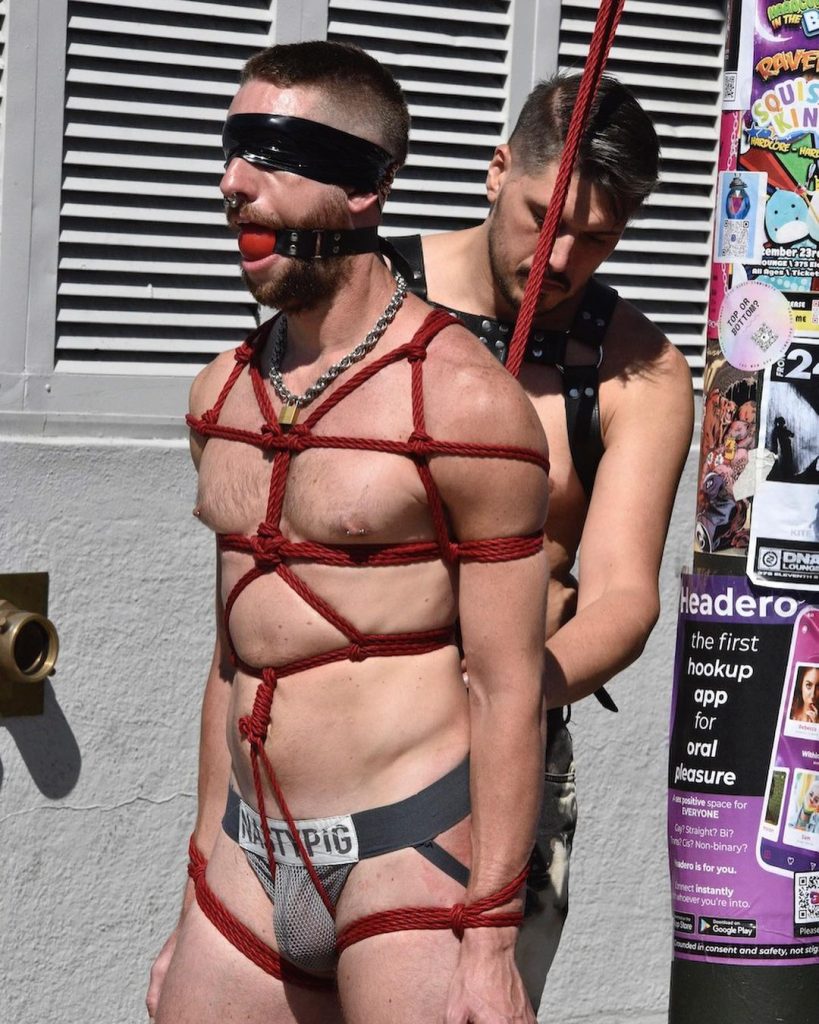 A man being tied up in bondage gear at Folsom 2022.