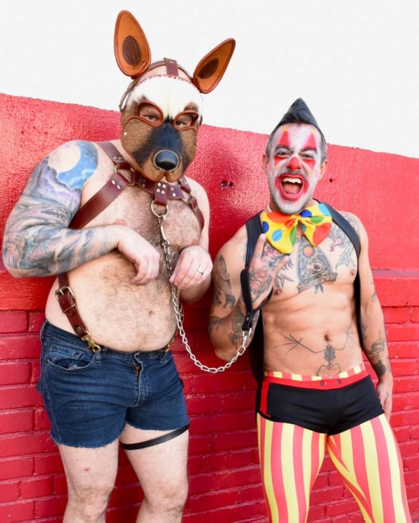 A man in a dog kink costume, and a man in a clown costume.