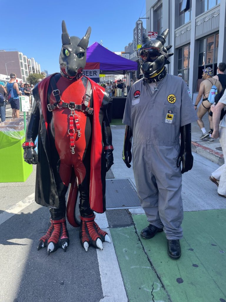 Two people dressed in dragon kink.