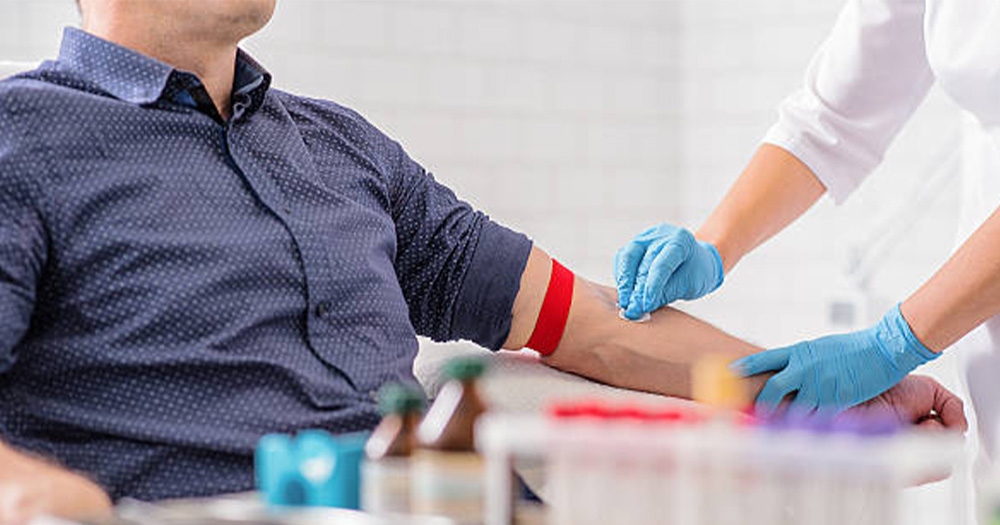 An image of someone donating their blood. There is a nurse preparing their arm.
