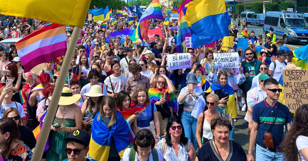 A crowd of participants with rainbow flags at Warsaw Pride in Poland