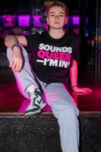 A model wearing a 'Sounds Queer I'm In' t-shirt from the new GCN collection.