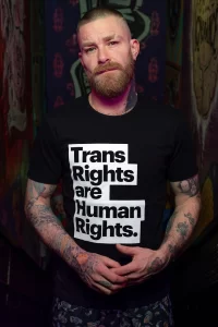 A model wearing a 'Trans Rights Are Human Rights' t-shirt from the new GCN collection.