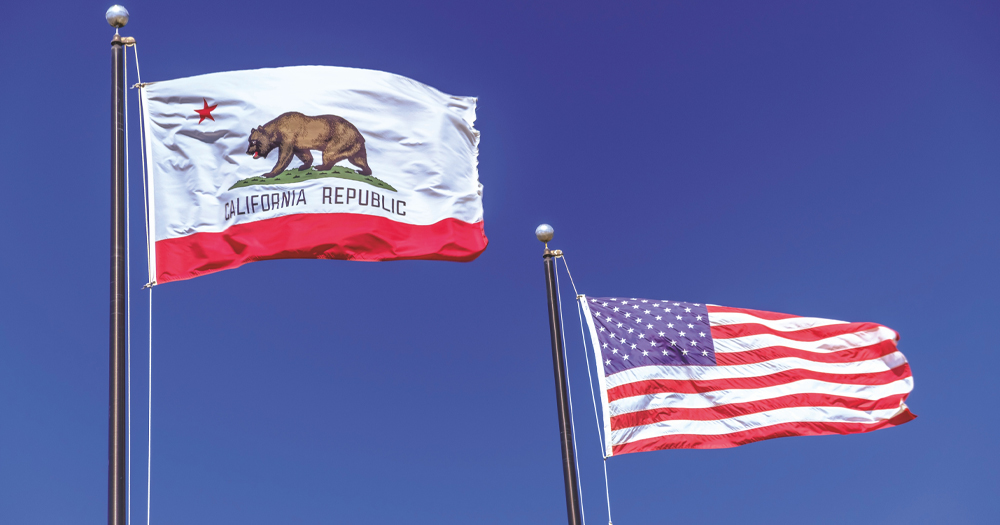 A flag of the state of California, which has passed a bill to protect Trans youth fleeing other US states, and a US flag.