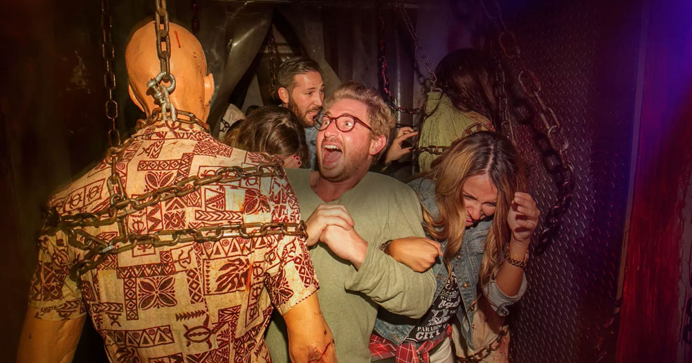 Screaming visitors to Halloween Horror Nights encounter a zombie