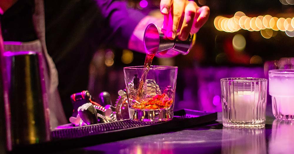 Hand pouring liquor in a clear glass because Irish nightclubs will be open late under new licensing laws.