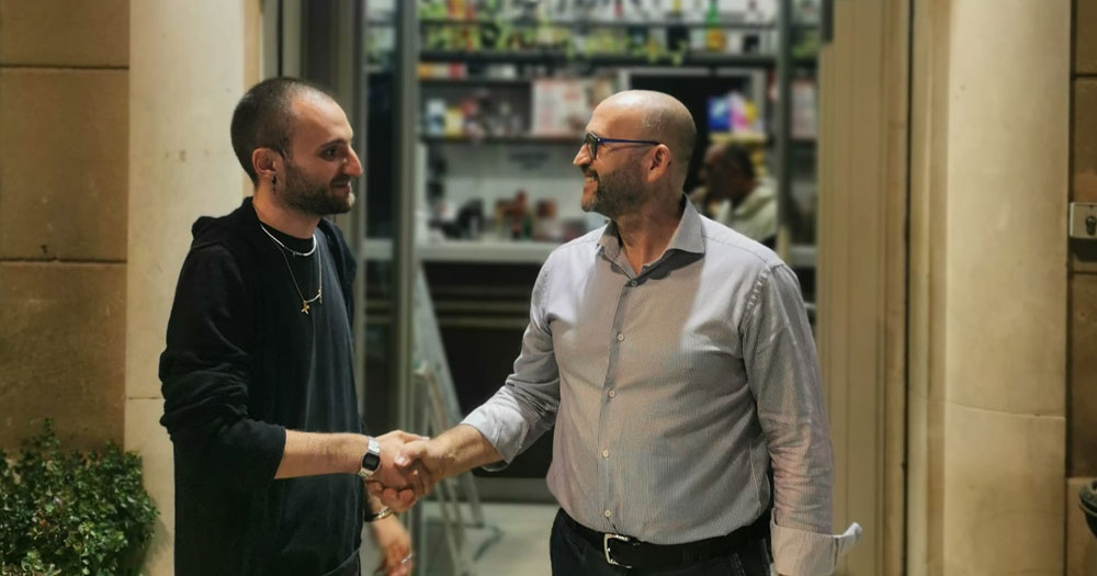 LGBTQ+ activist Andrea Ragusa and owner of the Italian bar Al Volo Salvatore Puglisi shaking hands.