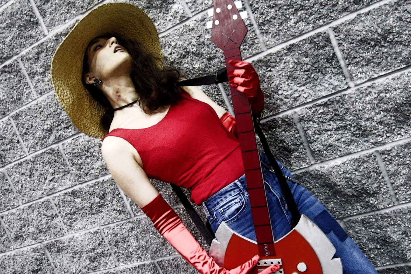 A person poses at a wall wearing a Marceline costume from Adventure time as a last minute Halloween costume.