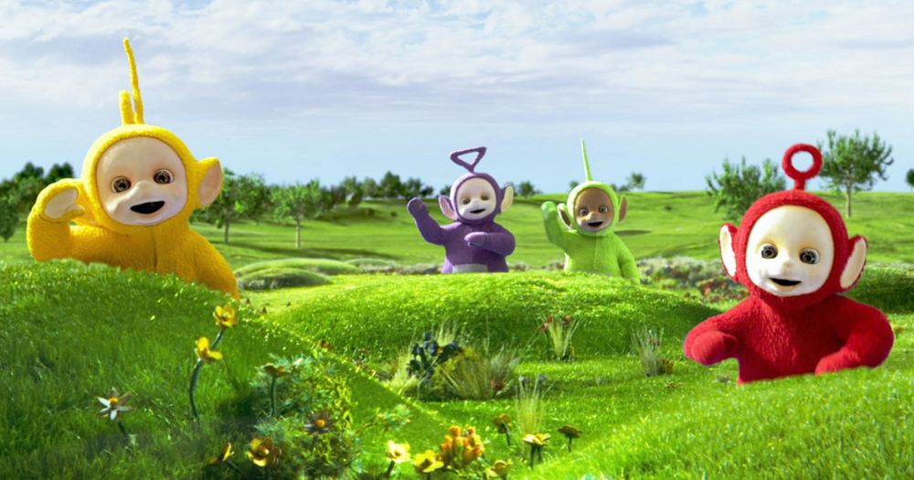 The Teletubbies from the Netflix reboot all stand around the green hills that are often seen in their show. Going from left to right we see Laa-laa, Tinky Winky, Dipsy, and Po all waving to the camera.