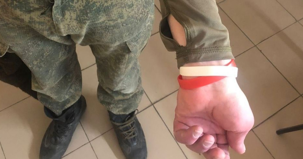 HIV-positive inmate recruited for the Russian military wears red and white wristbands to signify that they have HIV and hepatitis C.