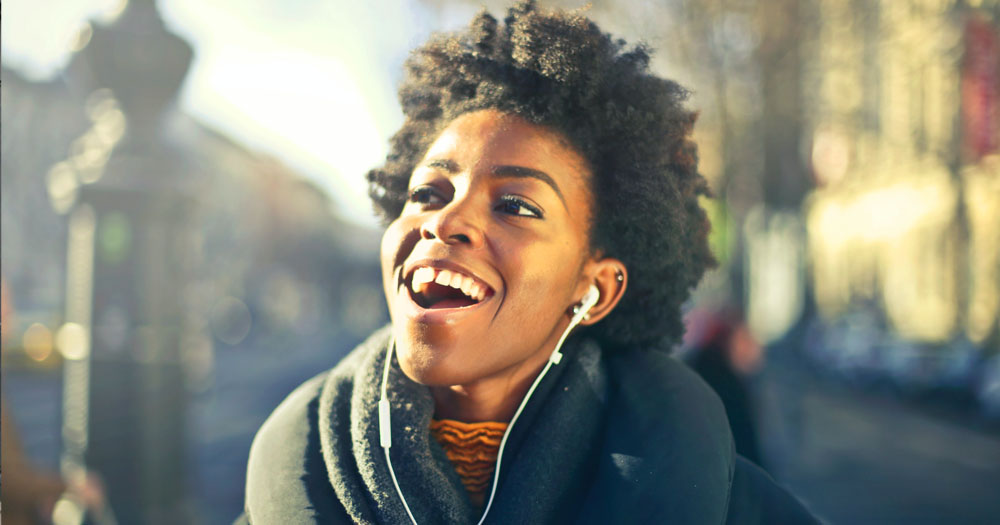 Dublin Lesbian Line have launched the second season of the Women Star podcast. The photograph shows a black woman listening to headphones grinning.