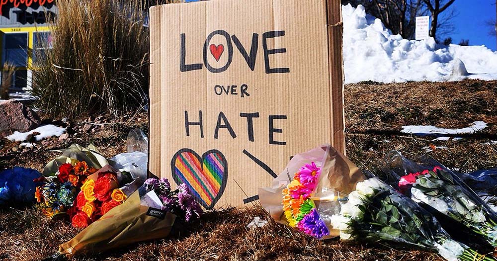 Flowers and signs with messages of love left after the mass shooting in Colorado Springs at LGBTQ+ venue Club Q.
