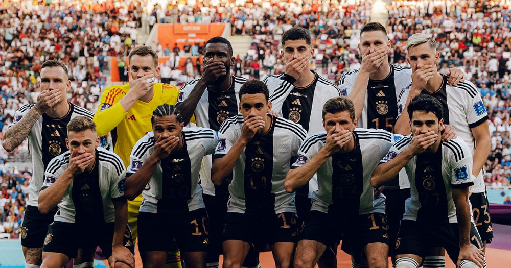 German football team at the first match of the Qatar World Cup, covering their mouths in defiance of FIFA's ban on the OneLove armband.