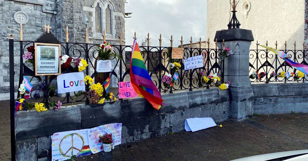 Pride flags and flowers brought by the LGBTQ+ community in Listowel in front of the church where priest gave homophobic sermon.