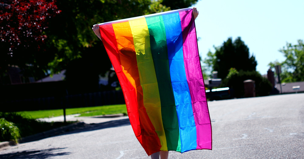 A picture of someone carrying a pride flag. The study explored the level of discrimination against LGBTQ+ youth, as well as a ‘negative halo’ of prejudice.