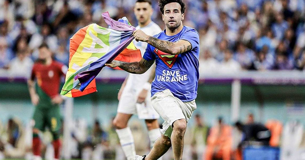 Activist Mario Ferri Falco carrying a rainbow flag in a pitch to protest Qatar World Cup.