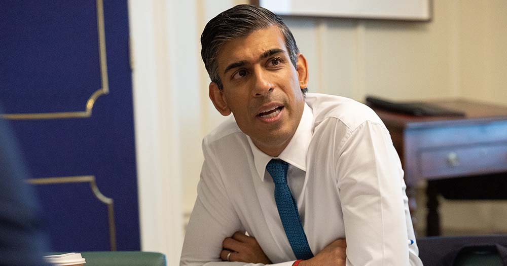 Rishi Sunak leans forward wearing a blue tie, he stated that he plans to amend the Equality Act to remove trans rights.
