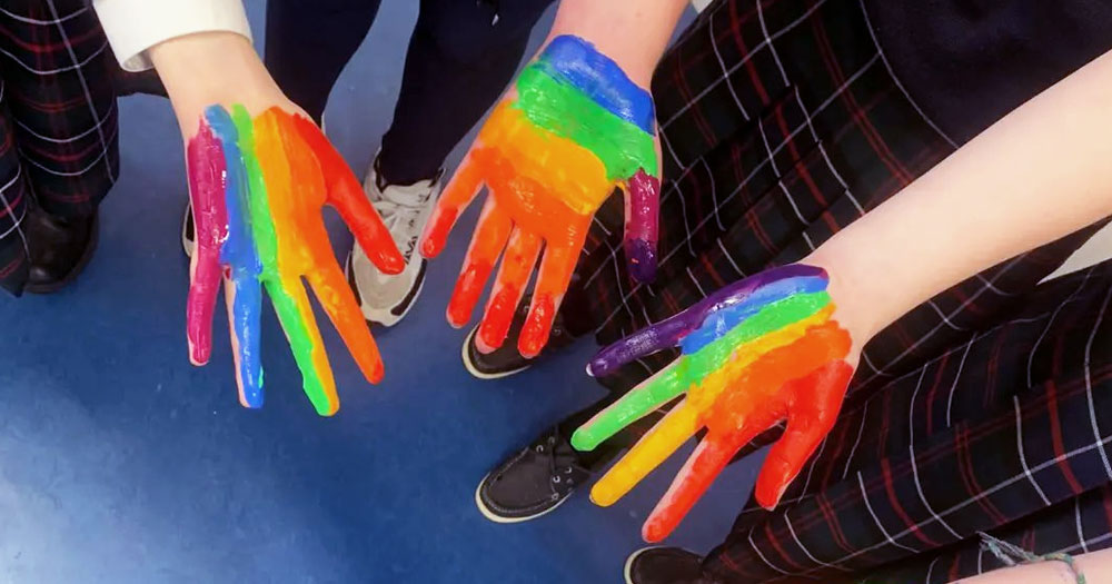 Hands painted in rainbow colours for Stand Up Awareness Week 2022.
