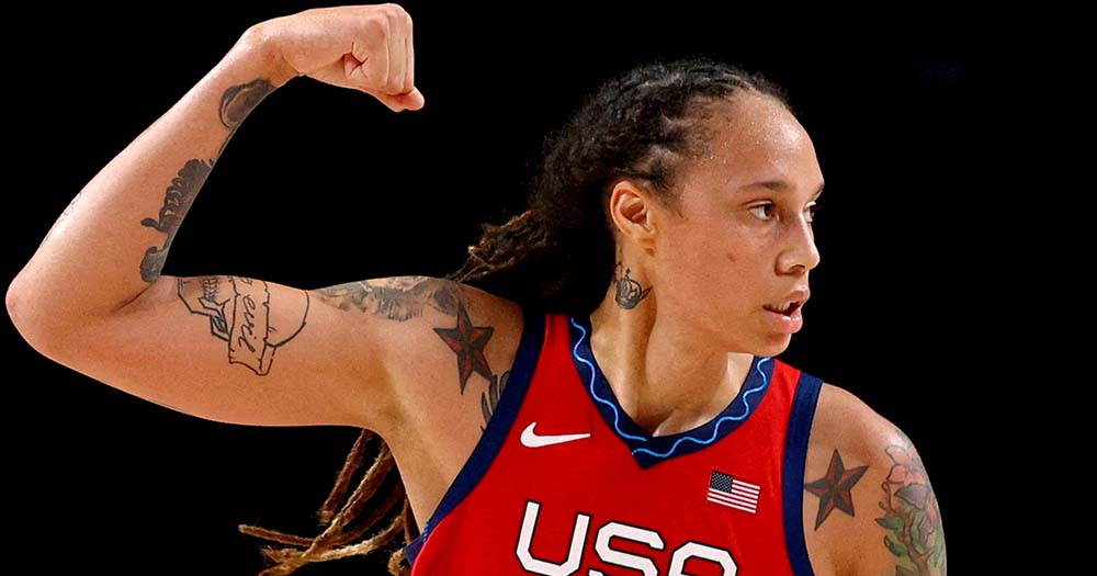 Brittney Griner poses in red jersey, this week she announced her return to basketball in 2023.