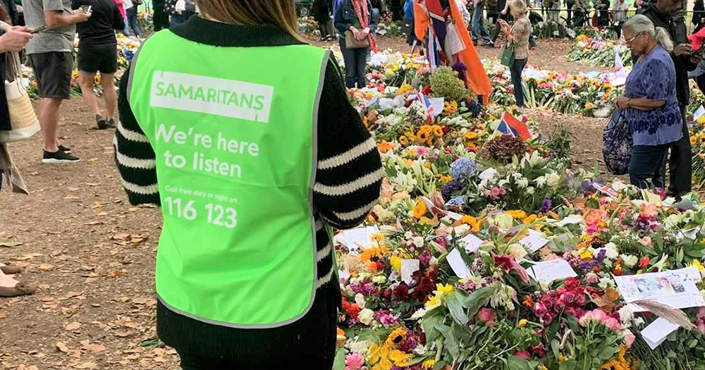 A person standing in a green Samaritans vest.