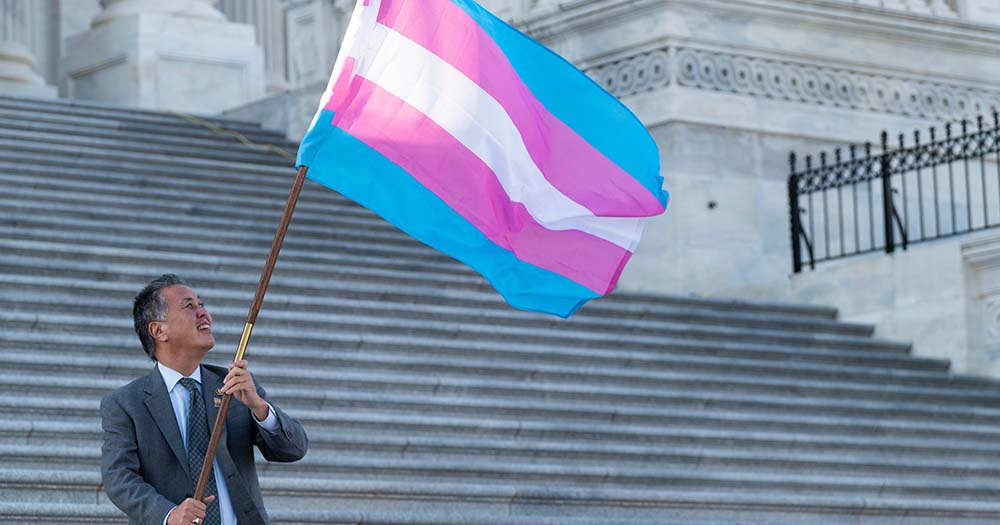A trans flag being waved as Spain and Scotland pass new laws.