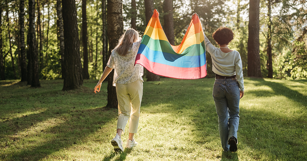 Two people hold a rainbow flag as Irish queers share hopes for 2023.