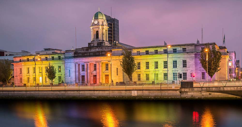 Cork City council building with rainbow lights projected on it, Cork is hosting the international Rainbow Cities Network Conference.